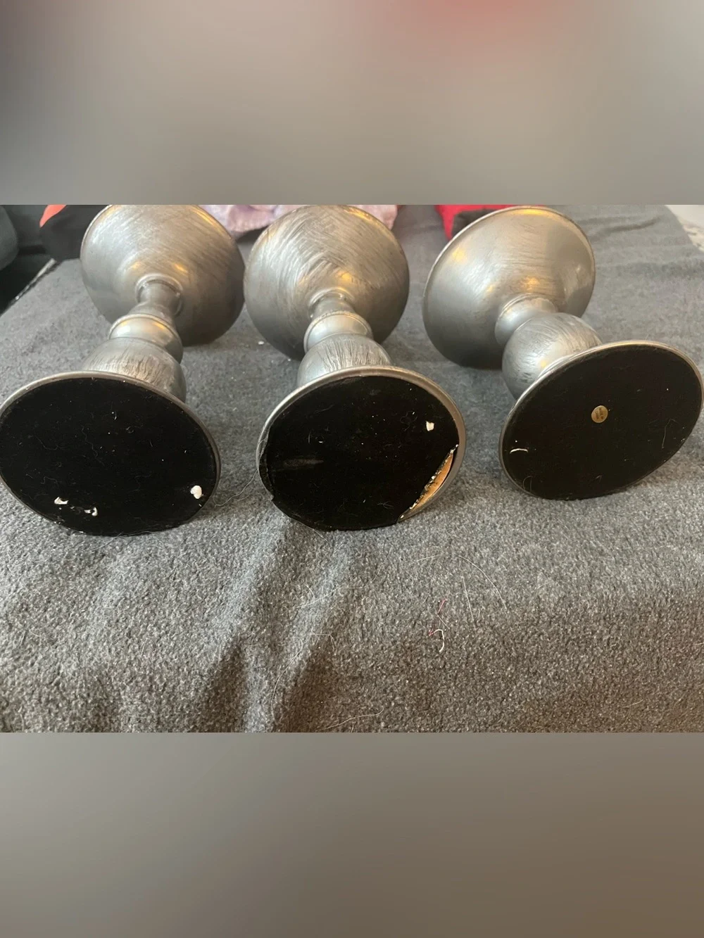 set of three silver-tone metal candlestick holders features a graduated design